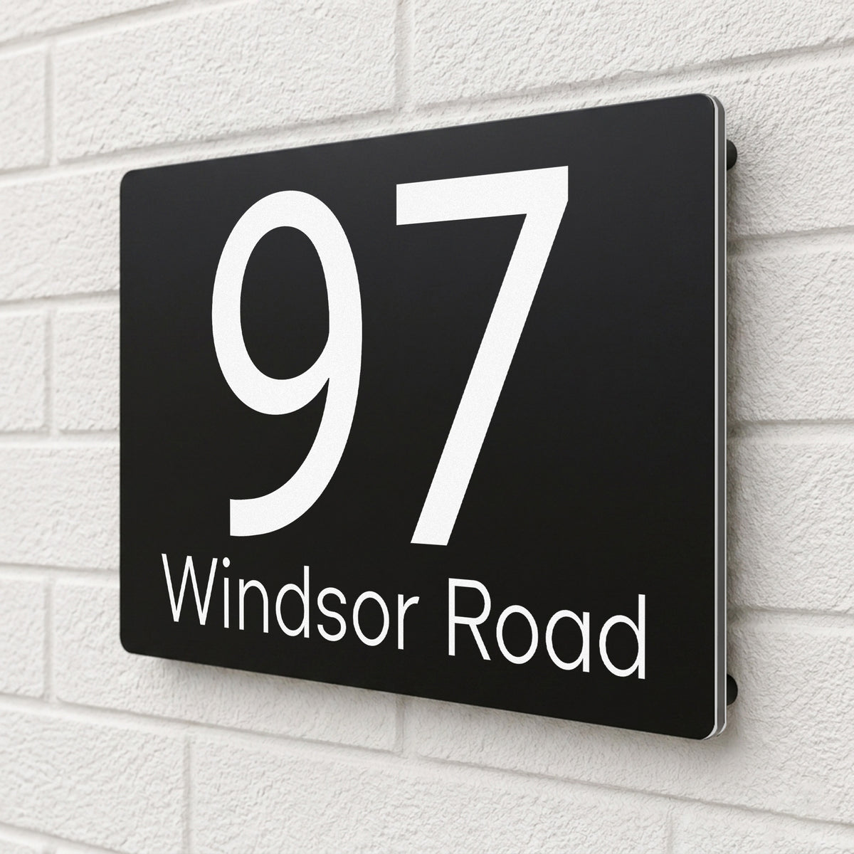 Side angle view of a black composite aluminium house sign personalised with '97 Windsor Road'