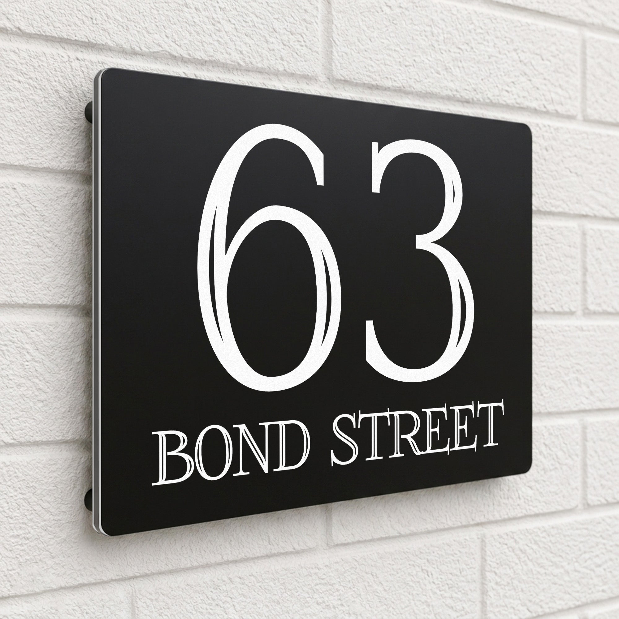 Black composite house sign personalised with '63 Bond Street' in a bold serif typeface