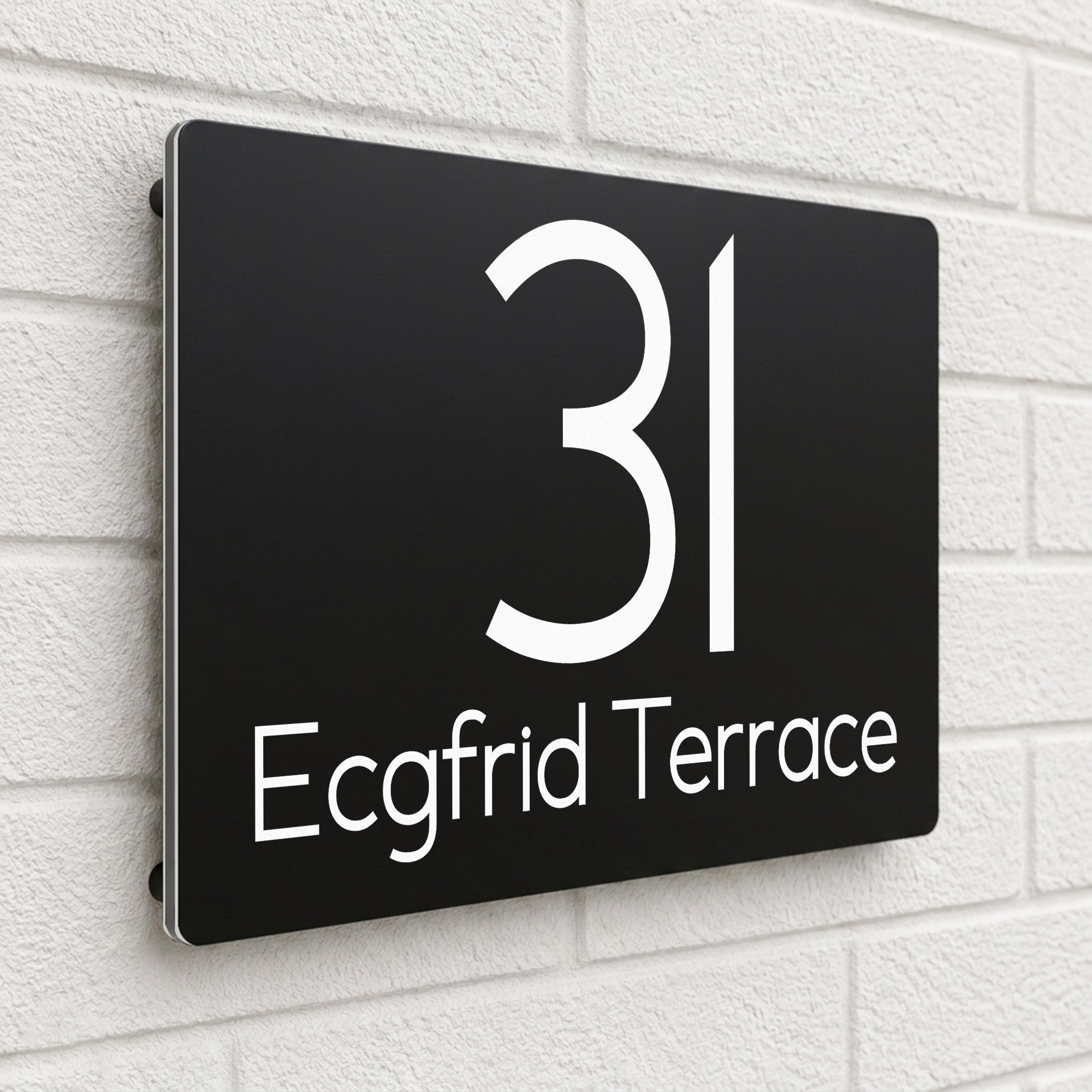 Black composite house sign personalised with '31 Ecgfrid Terrace' in a rounded modern font