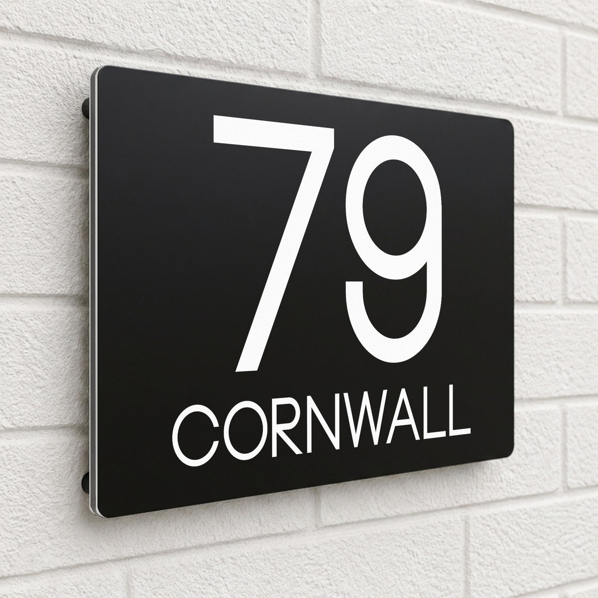 Black composite house sign personalised with '79 Cornwall' in bold capital letters