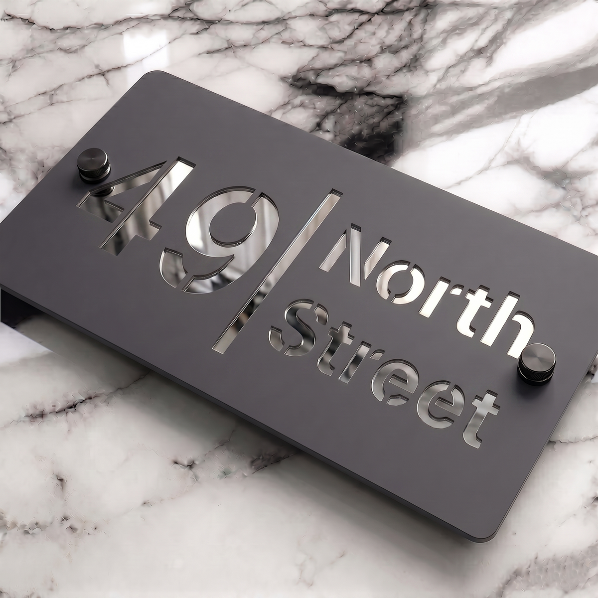 Lifestyle photo of a Grey Acrylic mirror house sign with Silver text beside a front door