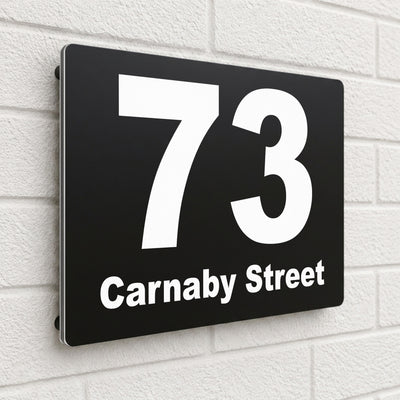 Black composite house sign personalised with '73 Carnaby Street' in a heavy modern font
