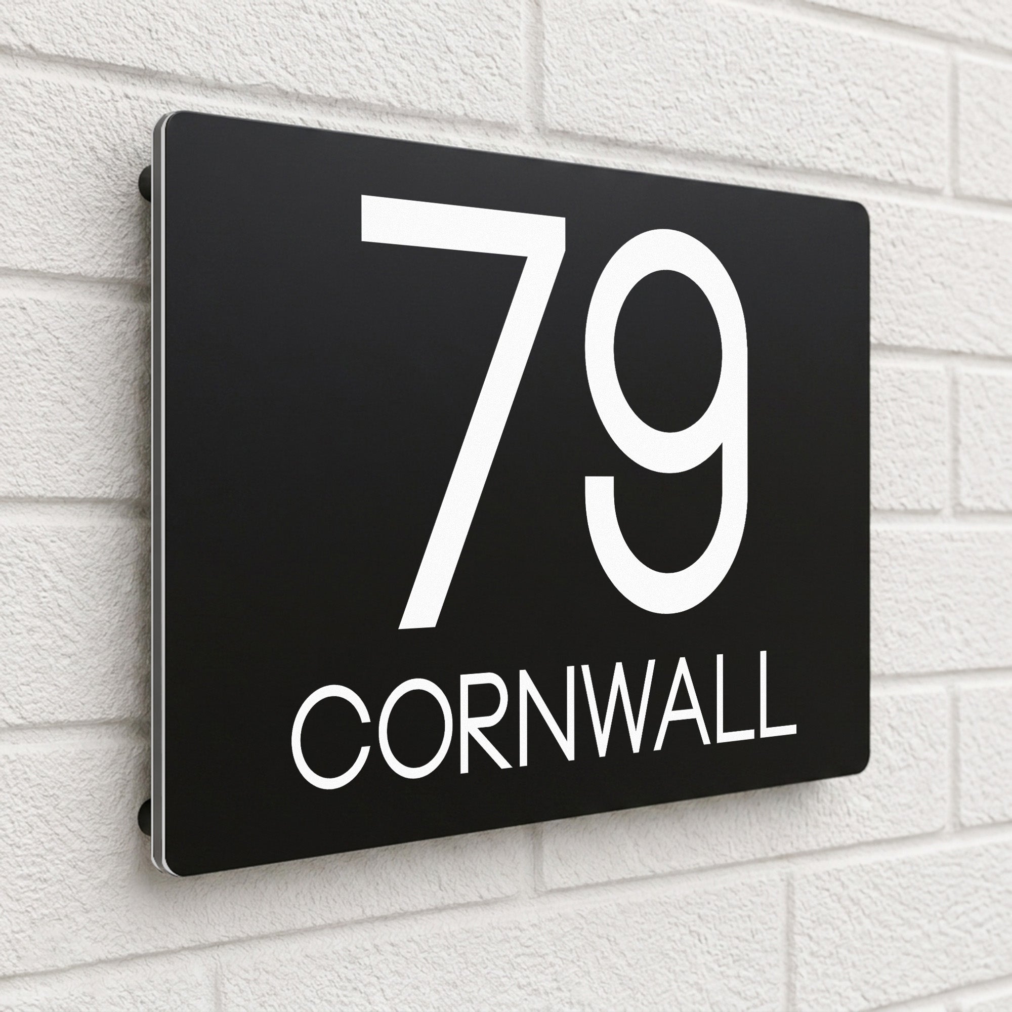 Black composite house sign personalised with '79 Cornwall' in bold capital letters