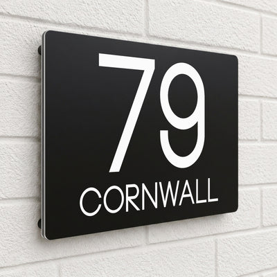 Black composite house sign personalised with '79 Cornwall' in bold capital letters