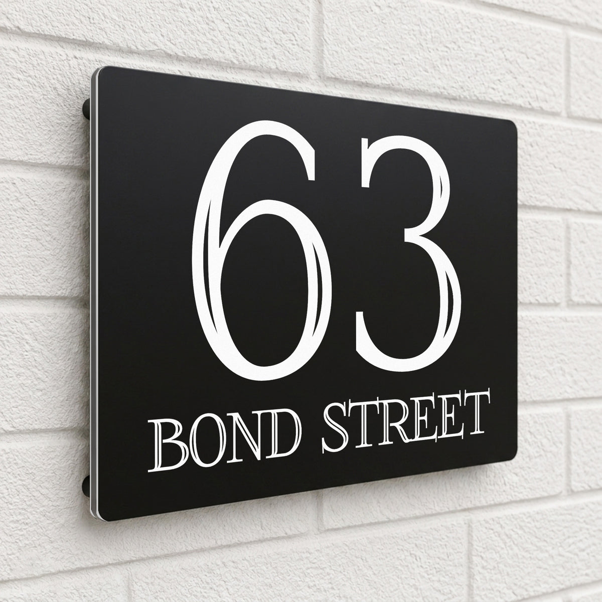 Black composite house sign personalised with '63 Bond Street' in a bold serif typeface
