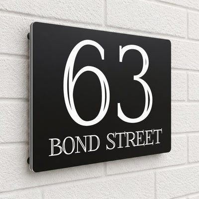 Black composite house sign personalised with '63 Bond Street' in a bold serif typeface