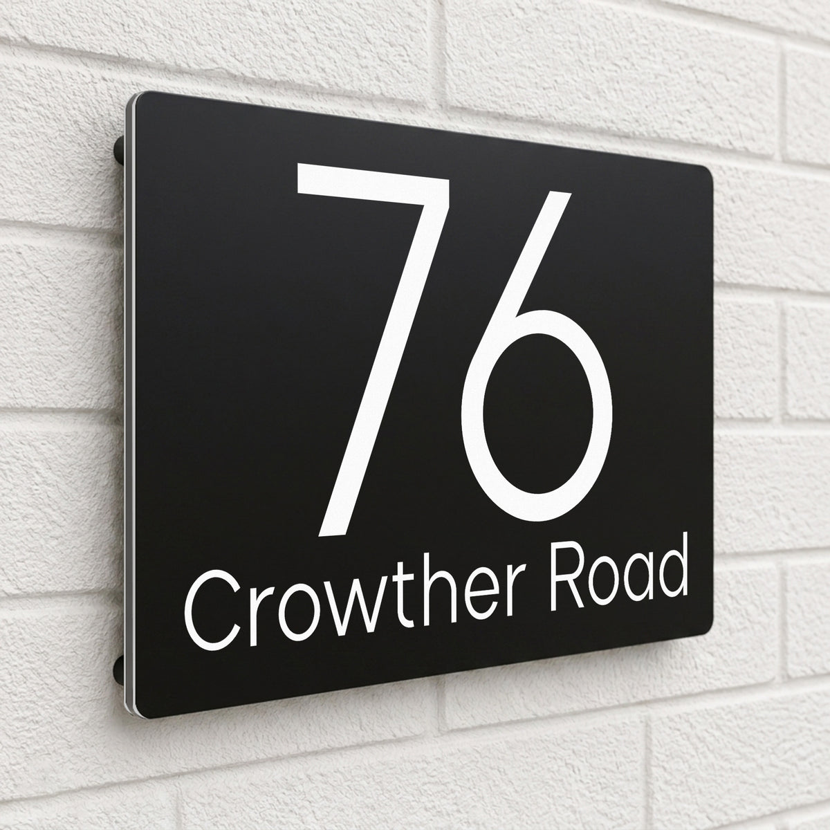 Black composite house sign personalised with '76 Crowther Road' in a light modern font