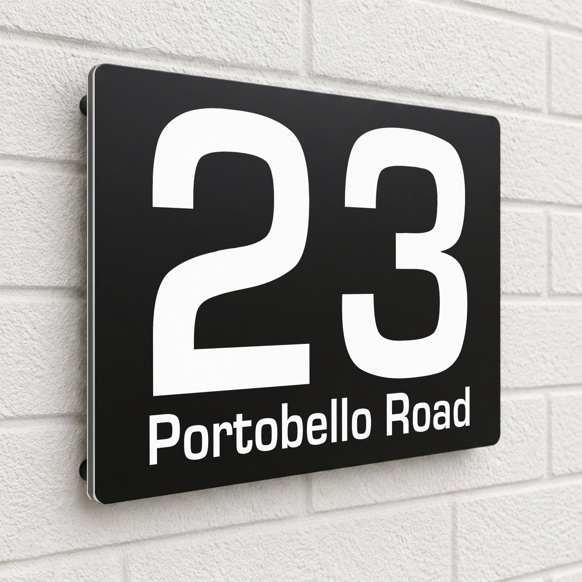 Black composite house sign personalised with '23 Portobello Road' in a clean sans-serif font