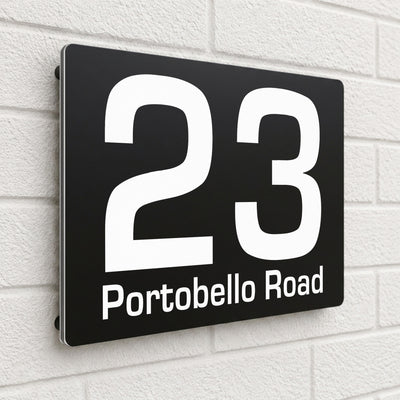 Black composite house sign personalised with '23 Portobello Road' in a clean sans-serif font