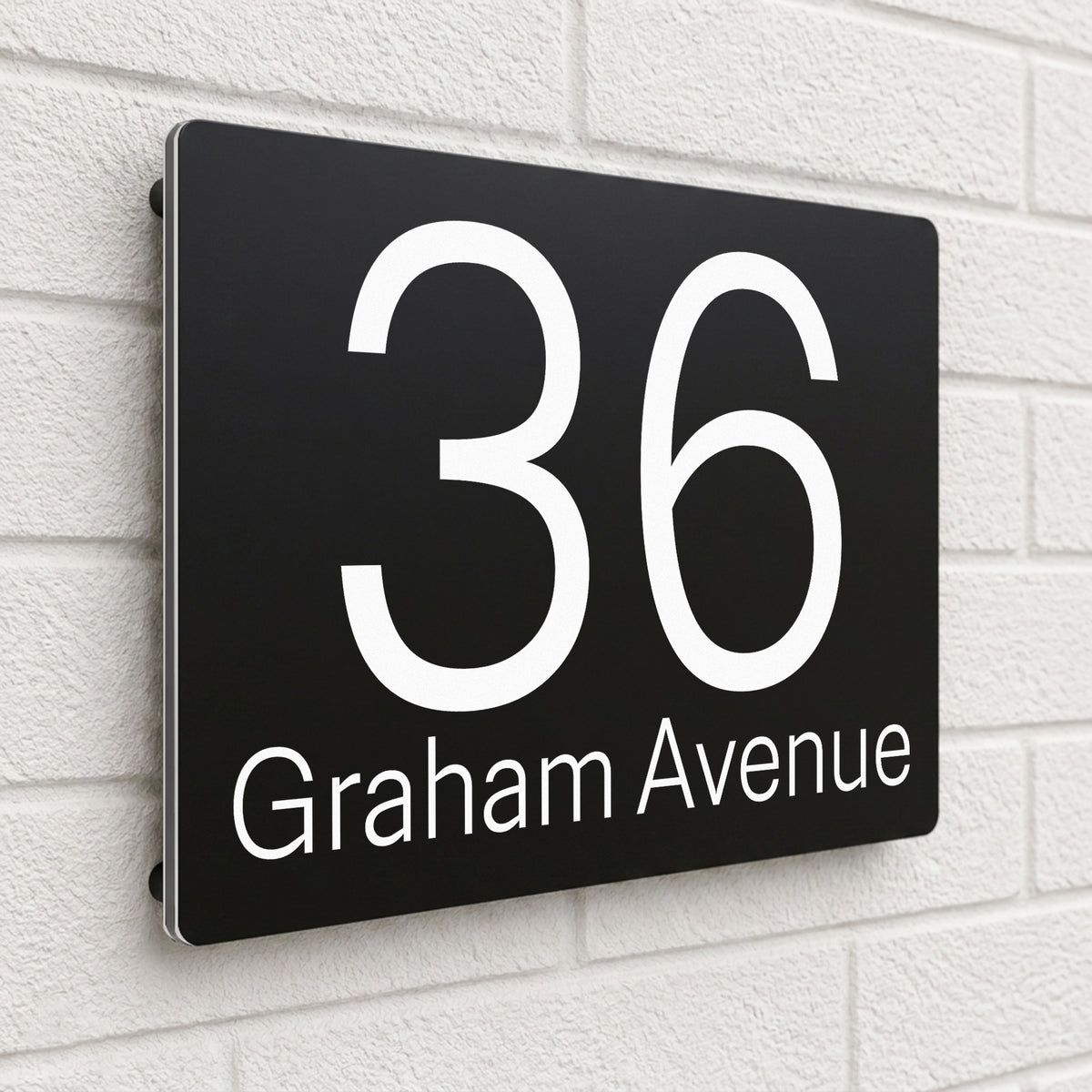 Black composite house sign personalised with '36 Graham Avenue' in a clean sans-serif font
