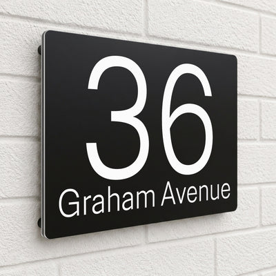 Black composite house sign personalised with '36 Graham Avenue' in a clean sans-serif font