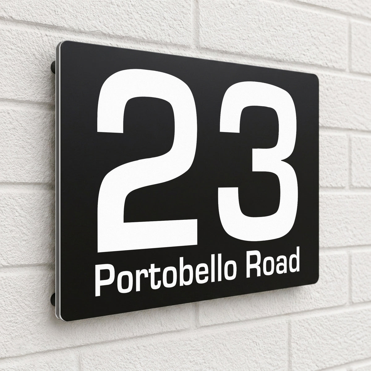 Black composite house sign personalised with '23 Portobello Road' in a clean sans-serif font