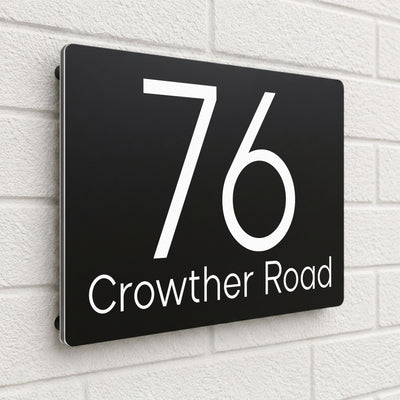 Black composite house sign personalised with '76 Crowther Road' in a light modern font