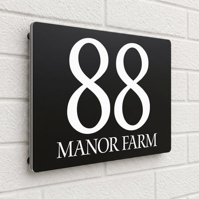 Black composite house sign personalised with '88 Manor Farm' in an elegant serif typeface