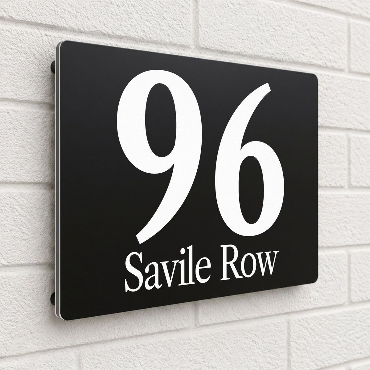 Black composite house sign personalised with '96 Savile Row' in an italic serif font