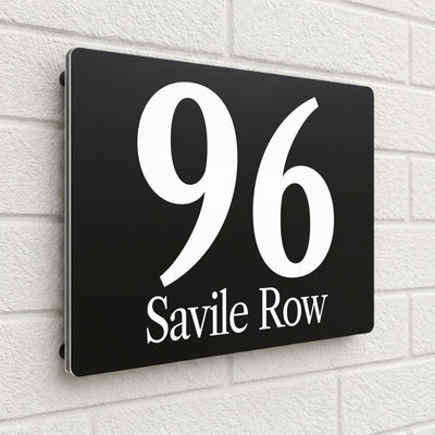 Black composite house sign personalised with '96 Savile Row' in an italic serif font