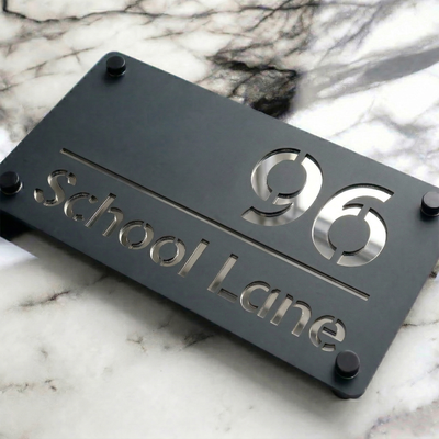 Lifestyle photo of a Grey Acrylic mirror house sign with Silver text beside a front door