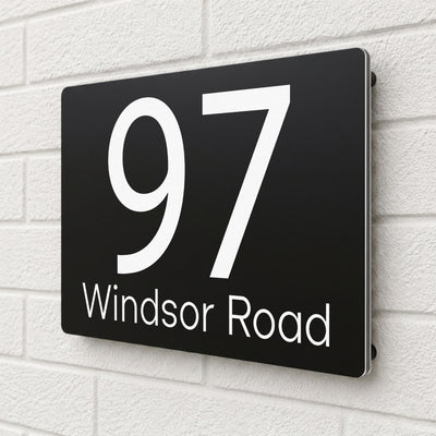 Side angle view of a black composite aluminium house sign personalised with '97 Windsor Road'